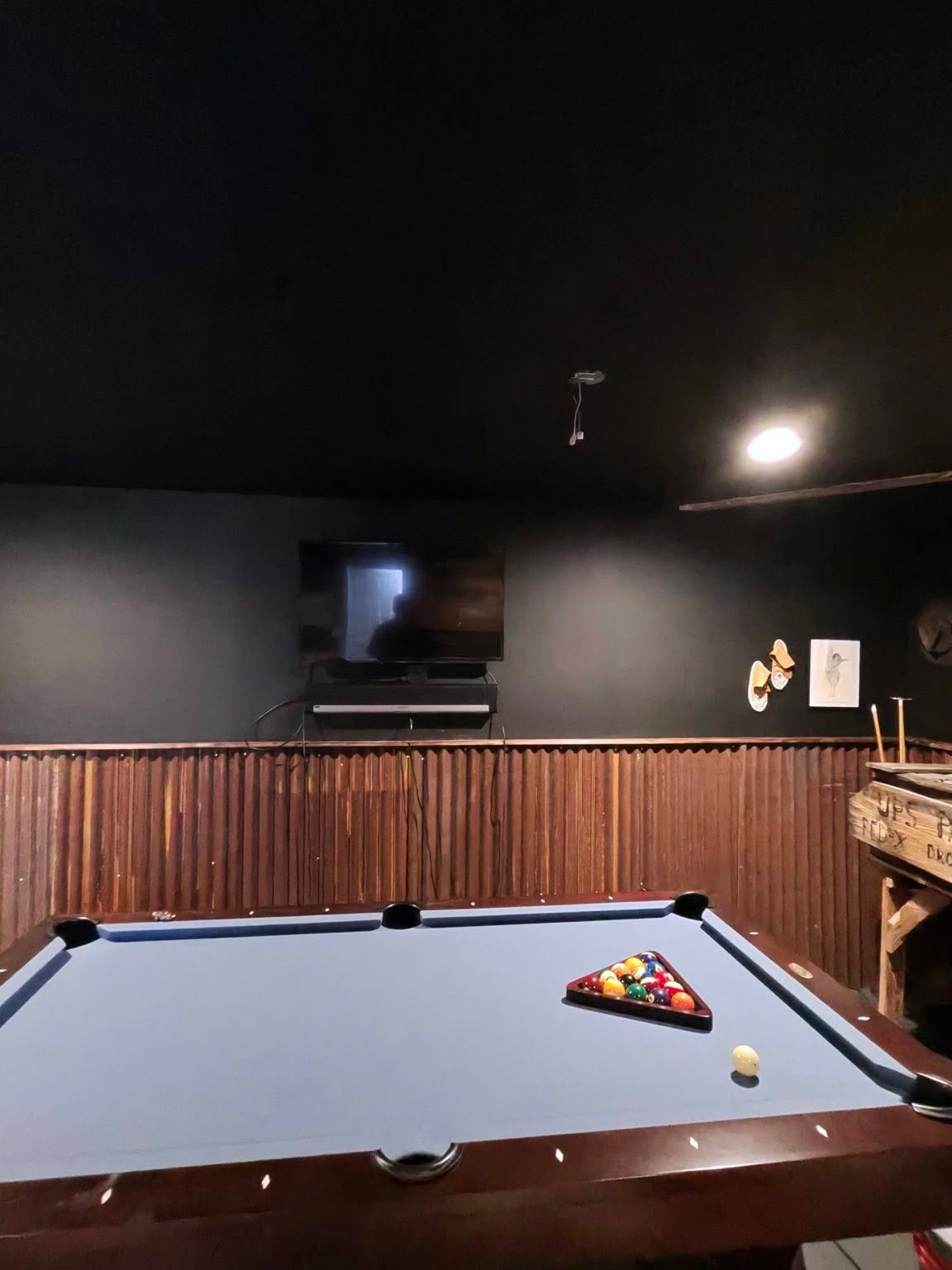 Finished corrugated metal and wood accent wall in game room