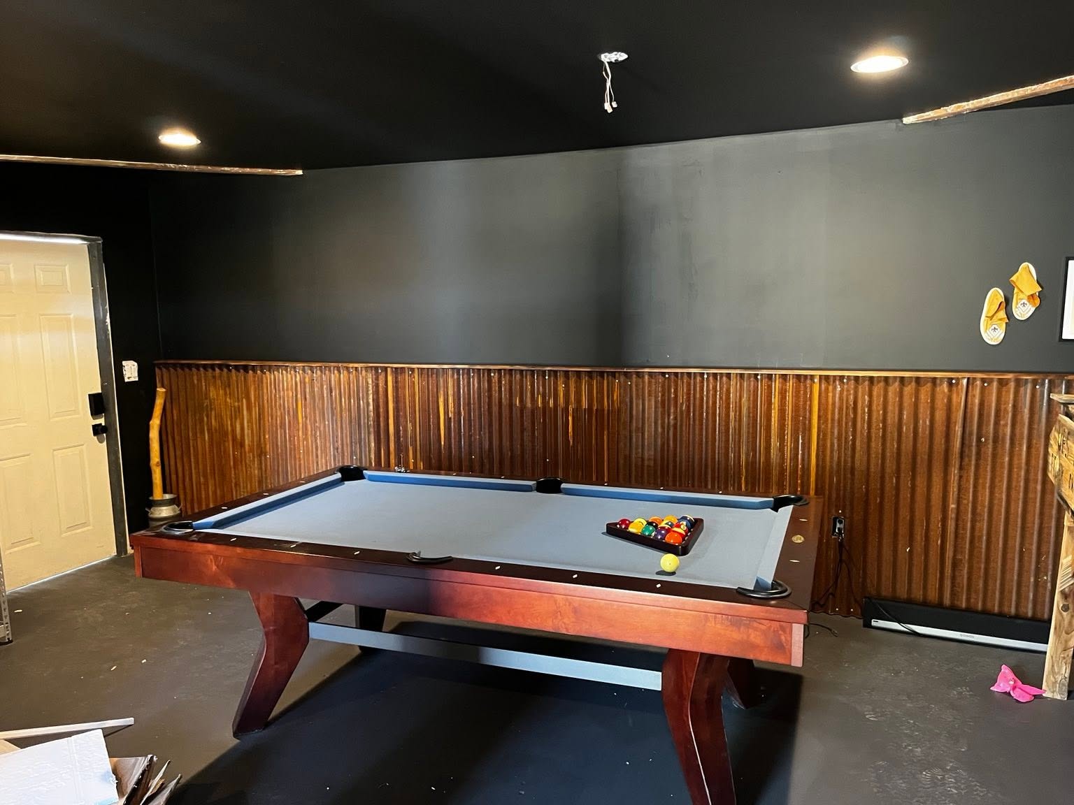Finished game room with pool table and dark accent walls